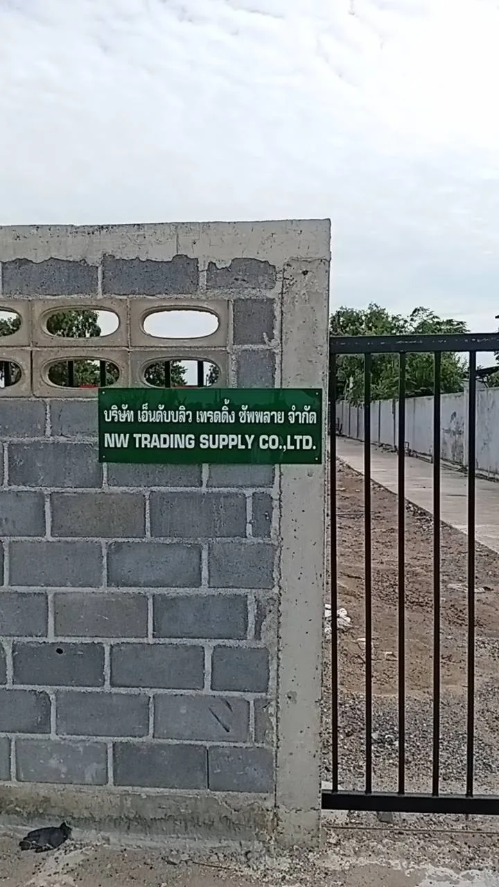 ป้ายชื่อบริษัท NW Trading Supply ติดที่กำแพงข้างประตูทางเข้า